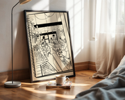 Framed black and white artwork on a wall next to a bed with a lamp and book.