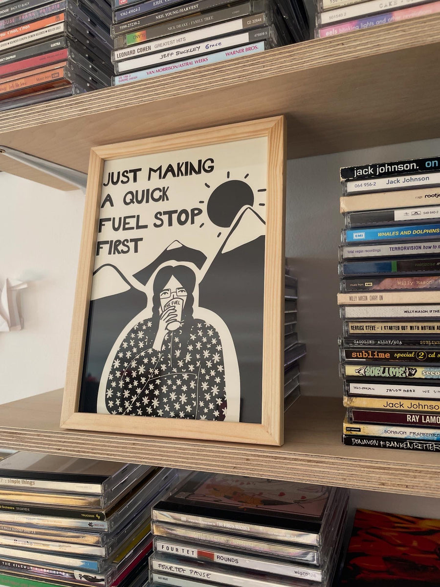Framed artwork on a shelf with CDs.