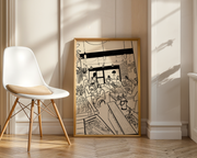 Framed black and white artwork on a wall next to a white chair with wooden legs.