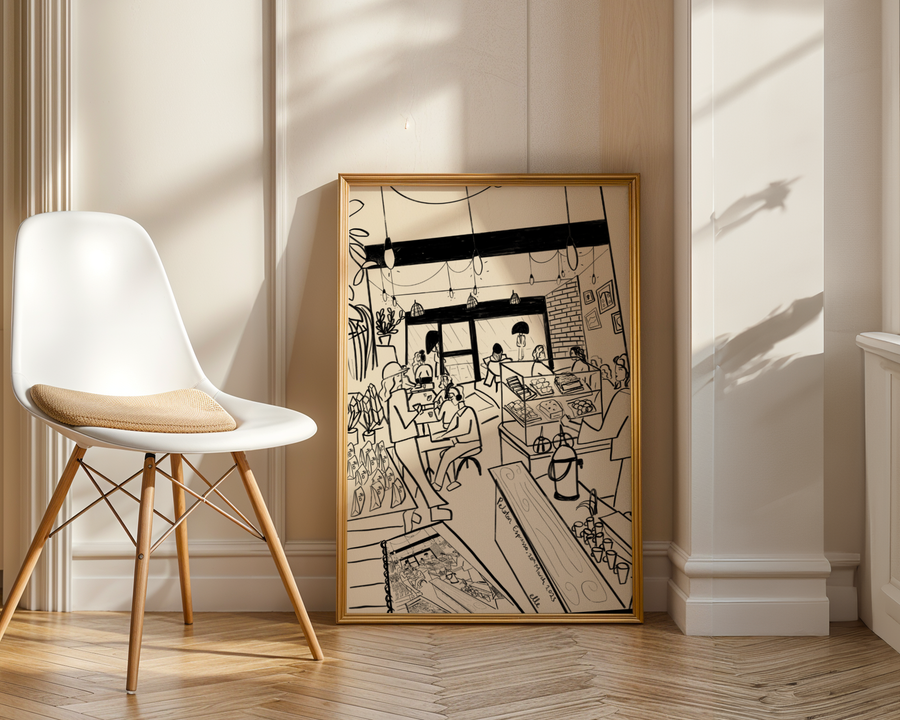 Framed black and white artwork on a wall next to a white chair with wooden legs.