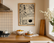Kitchen interior with a wooden countertop, bowl of fruit, and art print on the wall.